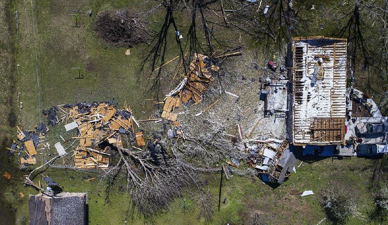 Pieces of a roof torn from a home in Higginson are scattered in the backyard Wednesday morning after a tornado hit the White County town Tuesday evening.