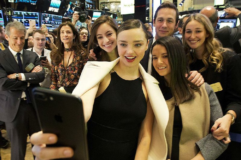 Model Miranda Kerr, who is engaged to Snapchat CEO Evan Spiegel, takes a selfi e with friends Thursday after the opening bell at the New York Stock Exchange.