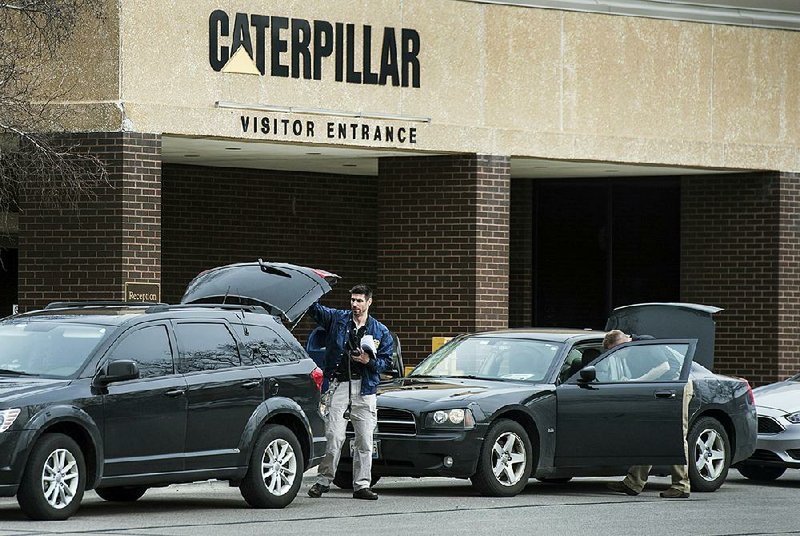 Federal officials collect supplies Thursday as they carry out a search at the Caterpillar Inc. plant in Morton, Ill.