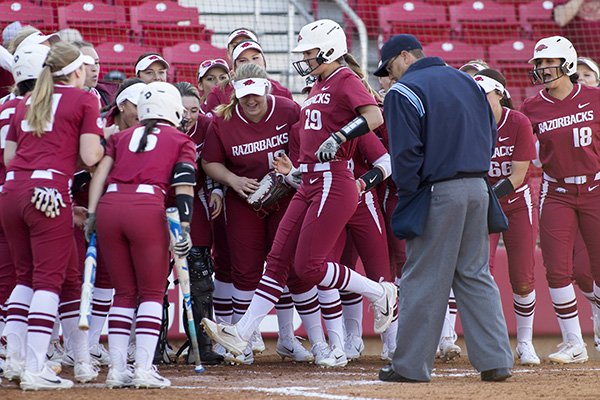 Arkansas players congratulate Nicole Schroeder (29) as she crosses the plate Friday, March 3, 2017, after Schroeder's two-run home run in the fourth inning against Nebraska at Bogle Park in Fayetteville.