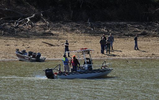 Officials from the Hickory Creek Fire Department search the waters Friday, March 3, 2017, from a department boat on Beaver Lake near U.S. 412 east of Springdale.
