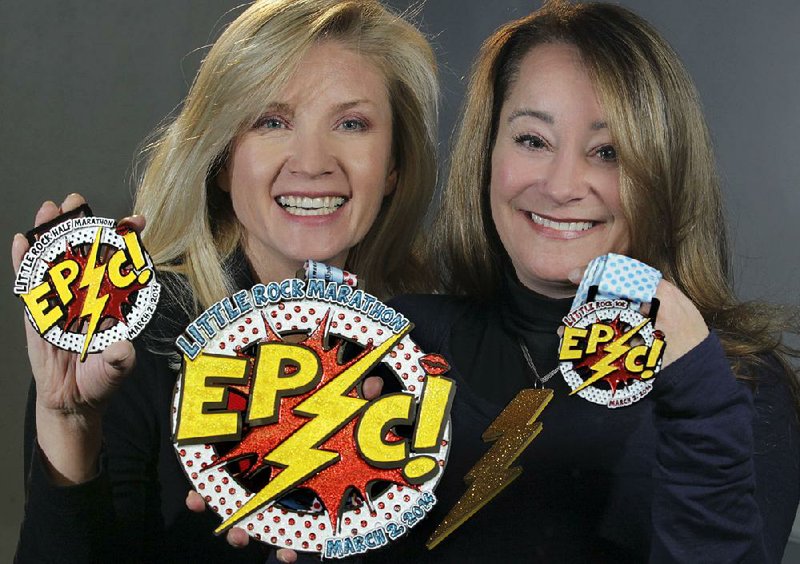 Little Rock Marathon race directors Geneva Lamm (left) and Gina Marchese Pharis show off the large medals used by the race in 2014. Lamm and Pharis try to come up with a theme each year and use memorable medals for finishers.