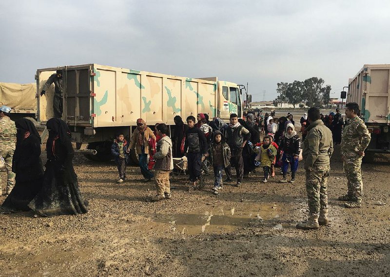 Civilians fleeing fighting in Mosul arrive Friday at an Iraqi army base. One woman described the escape, saying the children were given Valium so they wouldn’t cry during the flight on foot.