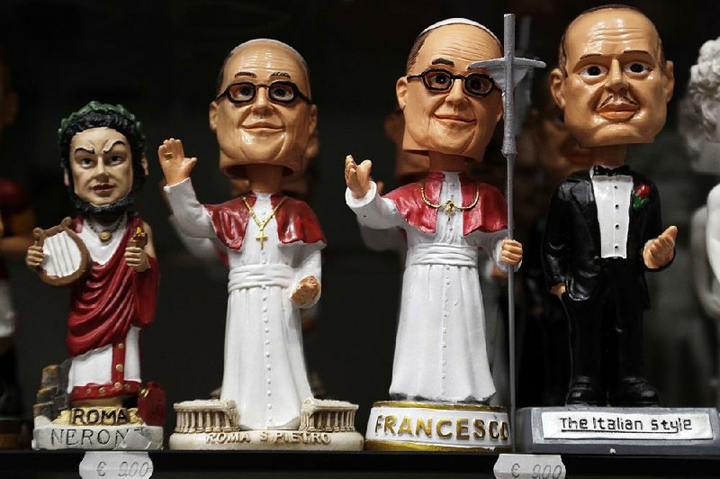 Pope Francis statuettes are displayed alongside figurines of the emperor Nero and “Godfather” figures at a shop in downtown Rome. 