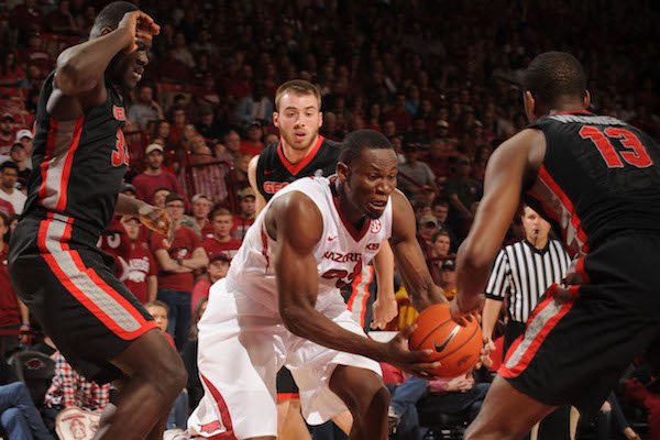 Arkansas forward Moses Kingsley (center) moves to the basket as Georgia forwards Derek Ogbeide (left) and E'Torrion Wilridge (13) defend Saturday, March 4, 2017, during the second half of play in Bud Walton Arena in Fayetteville.