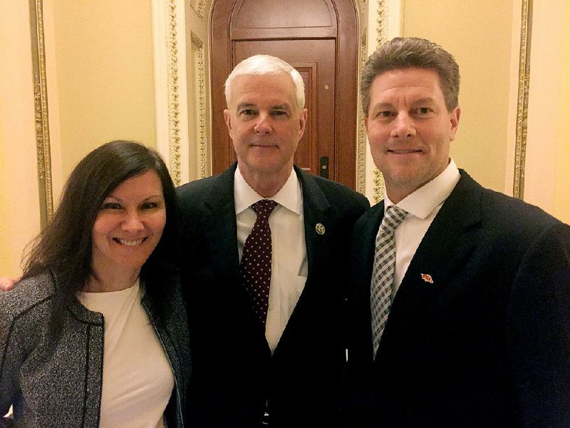 Doug and Chris Case of Fayetteville flank Arkansas’ U.S. Rep. Steve Womack outside the House chamber Tuesday after President Donald Trump spoke to a joint session of Congress.