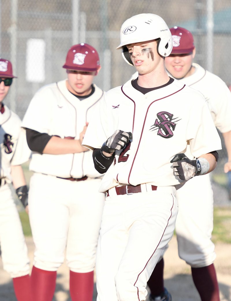 Bud Sullins/Special to Siloam Sunday Siloam Springs senior Chandler Cook is greeted by teammates after hitting a solo home run in the first inning against Springdale on Thursday at James Butts Baseball Park. The Bulldogs defeated the Panthers 4-2.