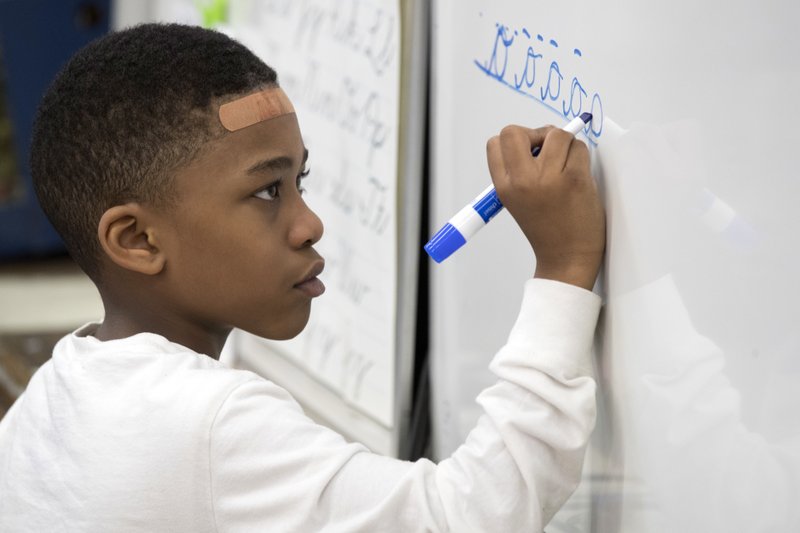 In this Wednesday, March 1, 2017, photo, a third-grader practices his cursive handwriting at P.S. 166 in the Queens borough of New York.