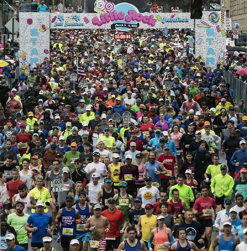 Runners burst from the starting line on Scott Street to begin the 2017 Little Rock Marathon. Nearly 2,500 braved a cold rain and mist to participate in the 15th running of the race, which covered 26.2 miles and began in downtown Little Rock.