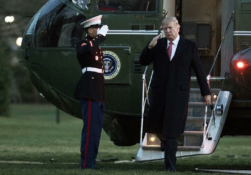 President Donald Trump salutes as he disembarks Marine One on Sunday upon arrival at the White House.