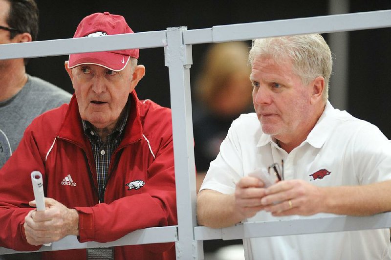 NWA Democrat-Gazette/ANDY SHUPE
Former Arkansas coach John McDonnell (left) and current coach Chris Bucknam speak Saturday, Feb. 11, 2017, during the Tyson Invitational in the Randal Tyson Track Center in Fayetteville. Visit nwadg.com/photos to see more photographs from the meet.