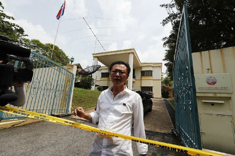 A North Korean Embassy staff member asks police if embassy personnel are allowed to leave as police cordon off the embassy Tuesday in Kuala Lumpur, Malaysia. 