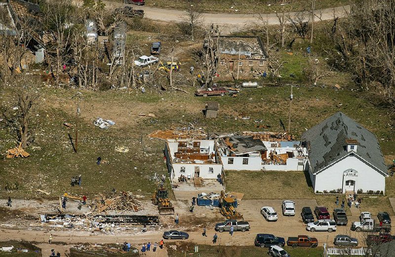 Workers spent Tuesday cleaning up downtown Parthenon, which was hit by an EF2 tornado late Monday night. A building that contained the post office (bottom left) and Parthenon First Baptist Church (at right) sustained the most damage in the Newton County community. More photos are available at arkansasonline.com/galleries. 