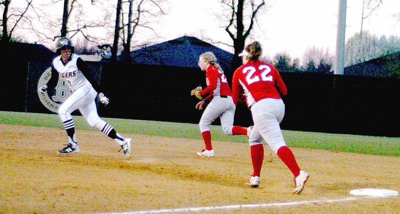 Photo by Mark Humphrey/Enterprise-Leader/Farmington first baseman Callie Harper, aided by the second baseman, chases a Bentonville runner caught between first and second base. The Lady Cardinals got the out in a rundown but lost 4-3 in their season-opener March 2.