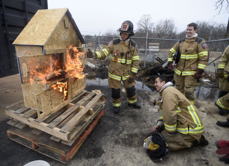 Capt. Joseph Shirley with the Fayetteville Fire Department (left) demonstrates fire movement in January on a model home as probationary firefighters Eric Nix (back right) and Chance Wright watch. The council is considering pay raises for city employees.