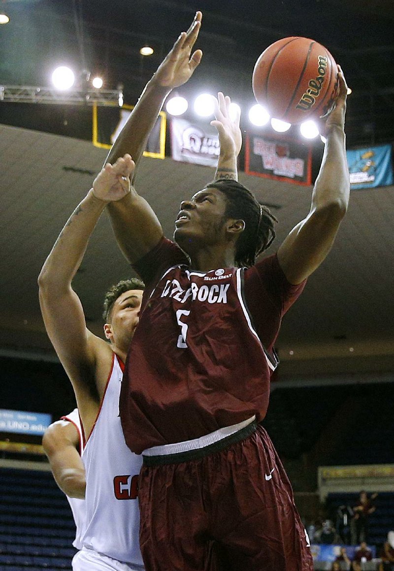 UALR forward Oliver Black (right) shoots over Louisiana-Lafayette defender Justin Miller during the Trojans’ 78-71 loss Wednesday in the opening round of the Sun Belt Conference Tournament.