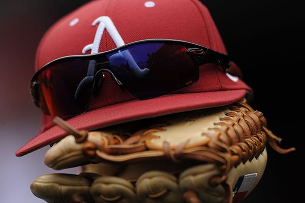 An Arkansas baseball hat and glove sit in the dugout prior to a game against Miami (Ohio) on Friday, Feb. 17, 2017, at Baum Stadium in Fayetteville. 