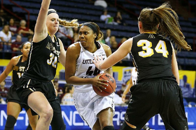 UALR forward Kaitlyn Pratt (center) drives between Appalachian State defenders Ashley Bassett-Smith (left) and Madi Story during the quarterfinals of the Sun Belt Conference Tournament on Thursday. Pratt had 20 points and eight rebounds in the Trojans’ 69-53 victory.