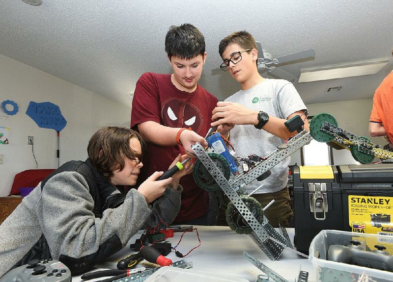 Roddy Little (from left), Gabriel Monterrosa and Hayden Blocker build a robot Wednesday at the Arkansas Arts Academy in Rogers.