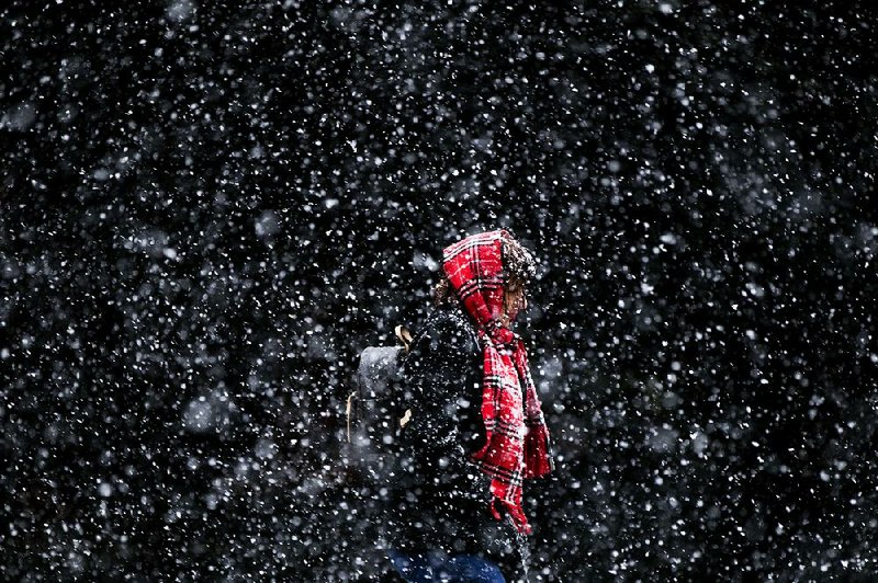A woman walks through heavy snow Friday in Philadelphia, which was hit by a system that dumped snow on much of the Northeast. Snow is in the forecast tonight for northern Arkansas, with as much as 2 inches accumulating before melting early Sunday. 
