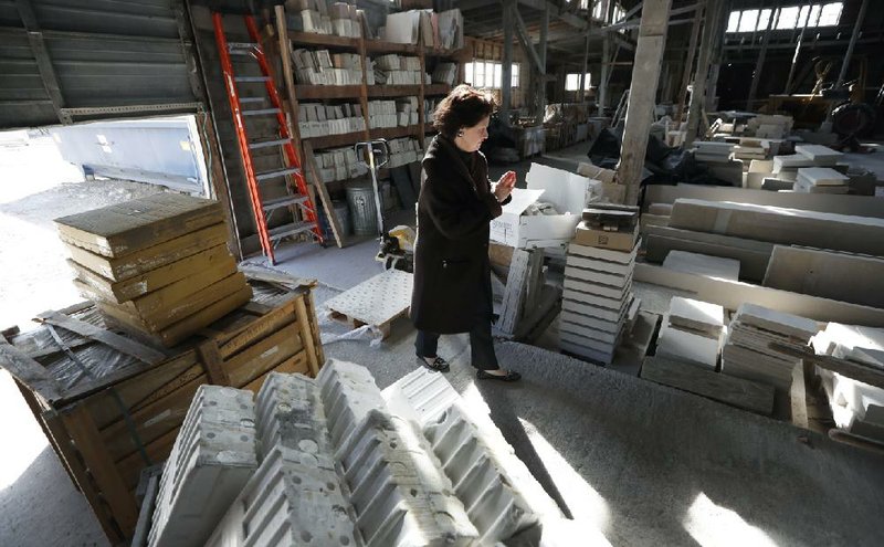 Teresa Van Vleet-Danos walks through the production area in the Rowat Cut Stone & Marble plant in Des Moines, Iowa, last month. 