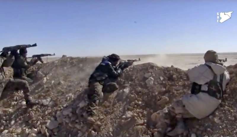 This frame grab from a video provided by the Syria Democratic Forces (SDF), shows fighters from the SDF opening fire on an Islamic State group's position, in Raqqa's eastern countryside, Syria, Monday, March 6, 2017. 