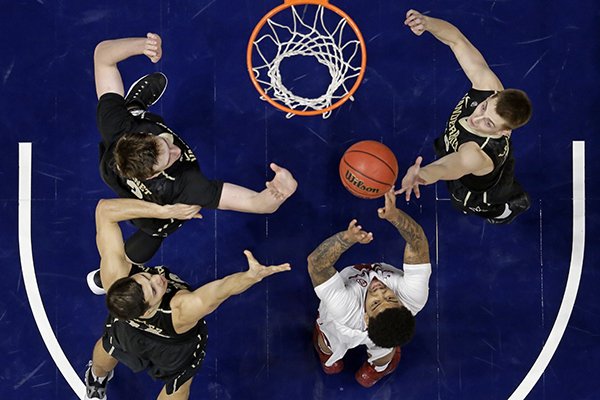 Arkansas guard Anton Beard, bottom right, reaches for a rebound with Vanderbilt's Luke Kornet, top left; Nolan Cressler, lower left; and Riley LaChance, top right; in the second half of an NCAA college basketball game in the semifinals of the Southeastern Conference tournament Saturday, March 11, 2017, in Nashville, Tenn. Arkansas won 76-62. (AP Photo/Mark Humphrey)

