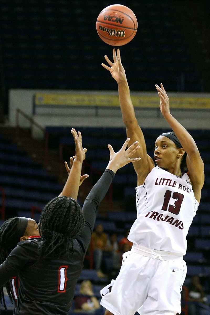 UALR Trojans guard Sharde Collins (13) shoots in front of two Louisiana-Lafayette defenders during the Trojans’ 79-71 loss to the Ragin’ Cajuns on Saturday in the semifinals of the Sun Belt Tournament at Lakefront Arena in New Orleans. Collins finished with a game-high 27 points. 