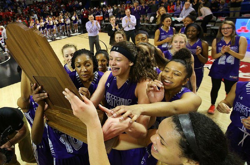 Fayetteville players celebrate with the trophy after defeating North Little Rock in the Class 7A girls championship game Saturday at Bank of the Ozarks Arena in Hot Springs. The Lady Bulldogs won the school’s seventh girls state title and thwarted the Lady Charging Wildcats’ attempt to win two in a row. 