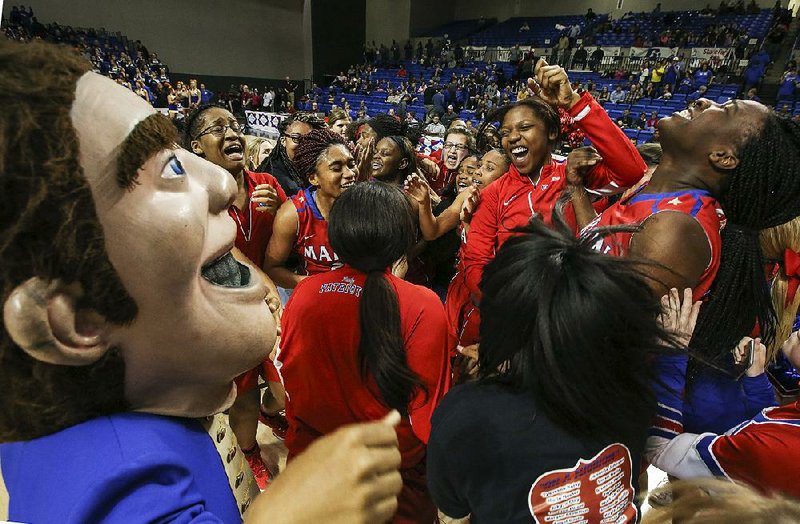 Marion players, students and the school mascot celebrate Friday after the Lady Patriots defeated the Sheridan Lady Yellowjackets 50-40 for the Class 6A girls state championship in Hot Springs. For more photos, visit arkansasonline.com/galleries.