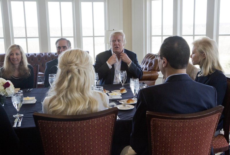 President Donald Trump, back center, meets, Secretary of Veterans Affairs David Shulkin, second from left, with his wife Merle Bari, left clockwise, Trump, Secretary of Commerce Wilbur Ross and his wife Hilary Geary, right, Treasury Secretary Steven Mnuchin and his fiancee Scottish actress Louise Linton, together with other members of his cabinet and the White House staff, Saturday, March 11, 2017, at the Trump National Golf Club in Sterling, Va. 