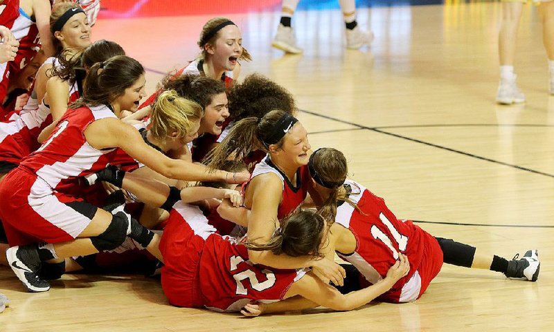 Pocahontas players tumble into a pile around their MVP Ashlyn Ellis (11) after a 54-46 overtime victory over Pottsville on Saturday at Bank of the Ozarks Arena in Hot Springs. For additional photos, go to arkansasonline.com/galleries