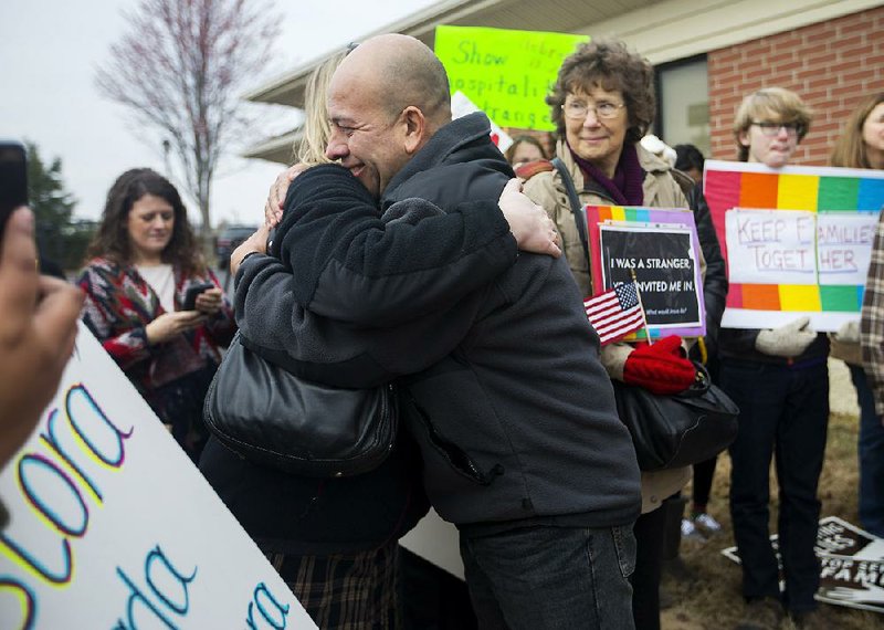 Jose Aristondo gets a hug Tuesday from Stephanie Red of Bentonville after Aristondo and his wife, Amanda, met with Immigration and Customs Enforcement officials in Fayetteville.