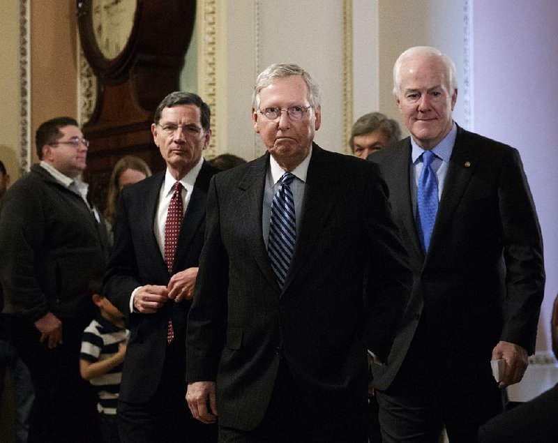 Senate Majority Leader Mitch McConnell (center) arrives to speak to reporters Tuesday with Sen. John Barrasso (left), R-Wyo., and Majority Whip John Cornyn of Texas. McConnell sought to play down party differences over the new health care proposal.