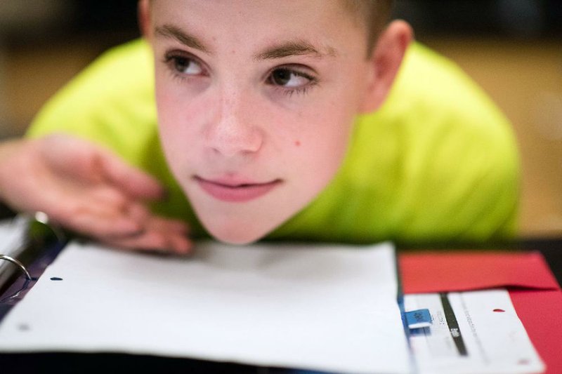Mike Keller, a 13-year-old with autism, listens to his science teacher at Lakelands Park Middle School in Gaithersburg, Md. Mike, who is nonverbal and communicates by spelling words on a keyboard, was able this year to “talk” for the first time using a personalized synthetic voice. 