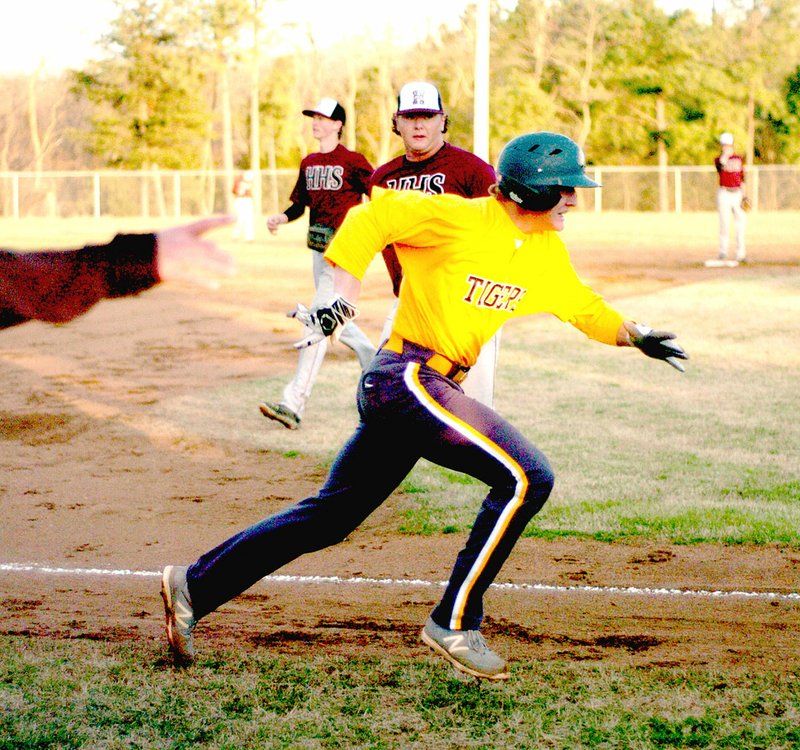 MARK HUMPHREY ENTERPRISE-LEADER Prairie Grove senior Clay Fidler is waved home by coach Chris Mileham. The Tigers upstaged a strong Huntsville squad on the baseball diamond, 4-3, on Friday.