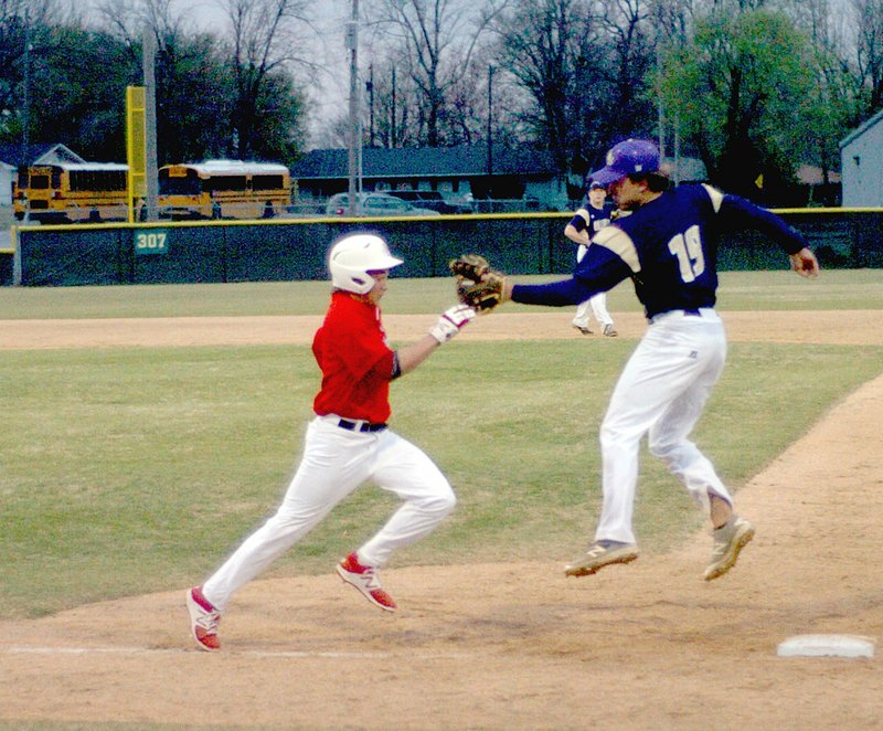 MARK HUMPREY ENTERPRISE LEADER Farmington sophomore Eric Hill tries to run by the tag of Ozark first baseman Bryant Burns. Hill was tagged out but Farmington won 8-1 at home March 6.