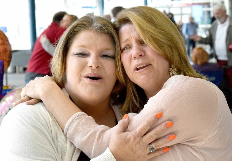 Photo by Mike Eckels Dawn Johnson (left) and Lisa Stokes share a hug during a reunion at Northwest Arkansas Regional Airport in Highfill on March 2. The two found out on Dec. 29, 2016, that they were full sisters, separated for 50 years.