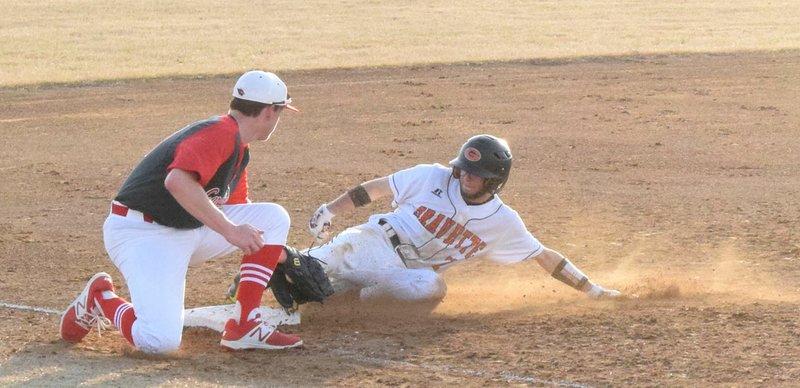 Photo by Mike Eckels Gravette center fielder William Owens (7) slides into third base before Farmington third baseman Ryan Larkin (21) could make the tag during the bottom of the third inning of the Lions-Cardinals varsity baseball game at Lion Stadium in Gravette March 9. Owens reached home plate for the first of his two runs.