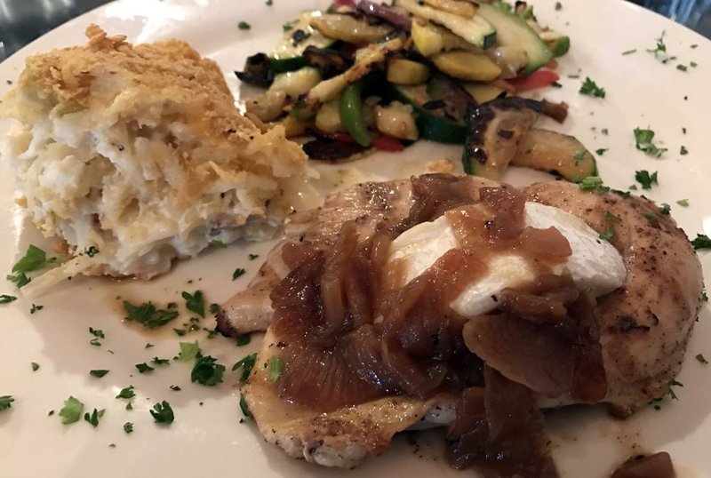 Grilled breast of chicken with melted brie and caramelized onions, served with vegetables and Capers Potatoes, is a lunch option at Capers.