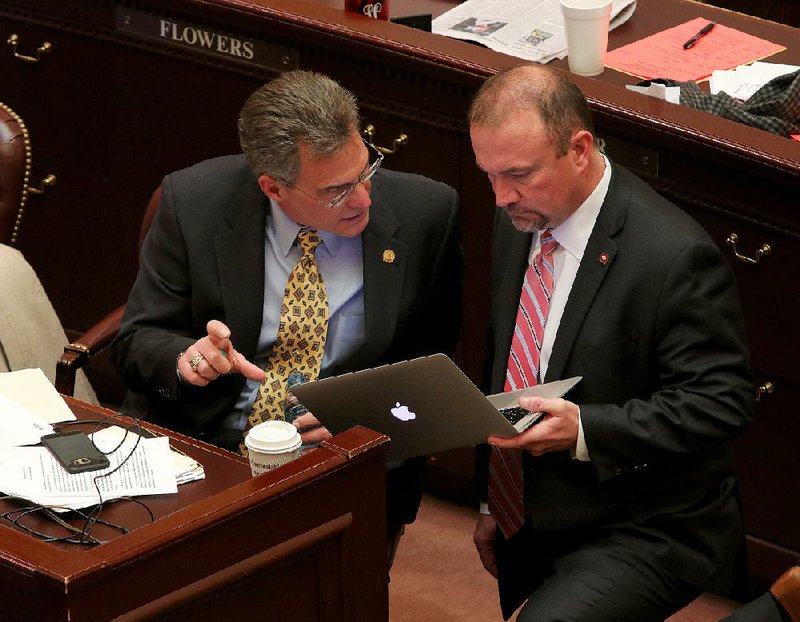 Rep. Charlie Collins (left) talks with Rep. Les Eaves, R-Searcy, during debate on the House floor Wednesday on Collins’ concealed-carry bill.