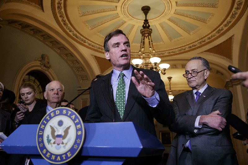 Sen. Mark Warner, D-Va., vice chair of the Intelligence Committee, center, flanked by Sen. Ben Cardin, D-Md., left, the ranking member on the Foreign Relations Committee, and Senate Minority Leader Chuck Schumer of N.Y., speaks during a news conference on Capitol Hill in Washington, Wednesday, Feb. 15, 2017.  