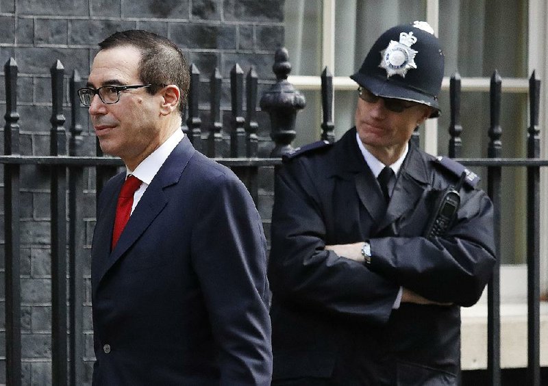 U.S. Secretary of the Treasury Steven Mnuchin passes a police officer Thursday on Downing Street to meet Britain’s Chancellor of the Exchequer Philip Hammond in London. 