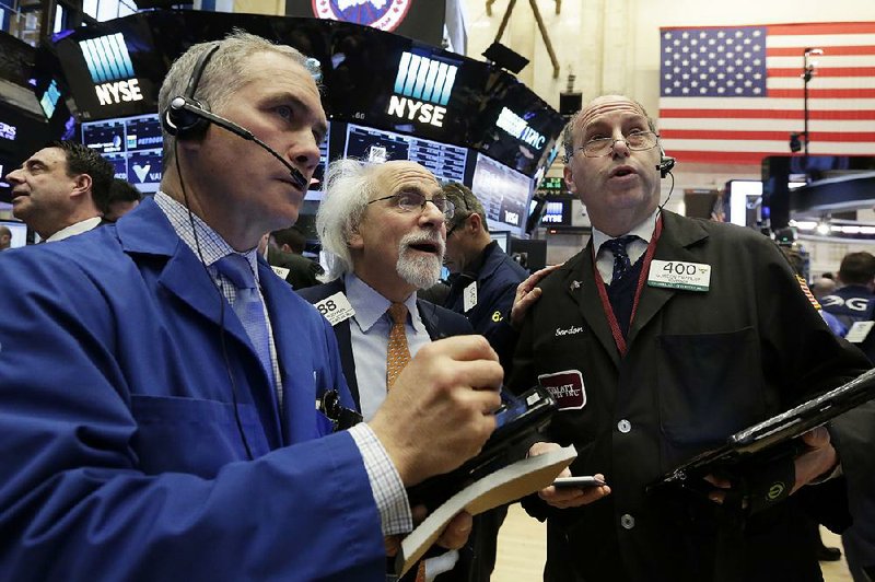 Traders Timothy Nick (from left), Peter Tuchman and Gordon Charlop work Thursday on the floor of the New York Stock Exchange. 