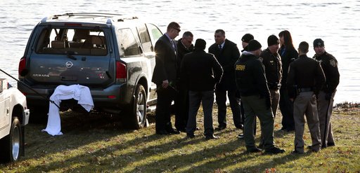 Law enforcement work beside Silver Lake near an SUV that was found in the water with a baby inside in Highland, Ill., on Thursday, March 16, 2017.