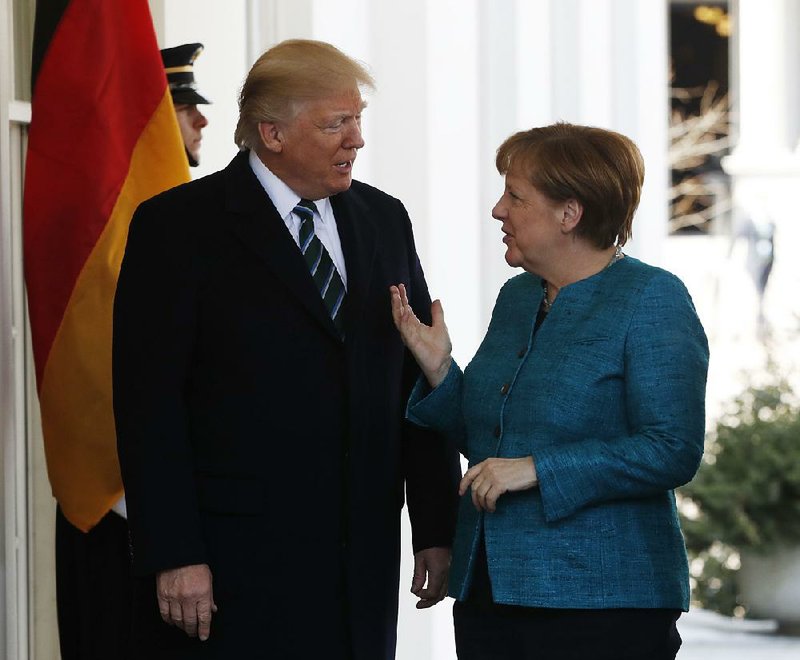 President Donald Trump greets German Chancellor Angela Merkel as she arrives at the White House on Friday for the first meeting of the two leaders. 