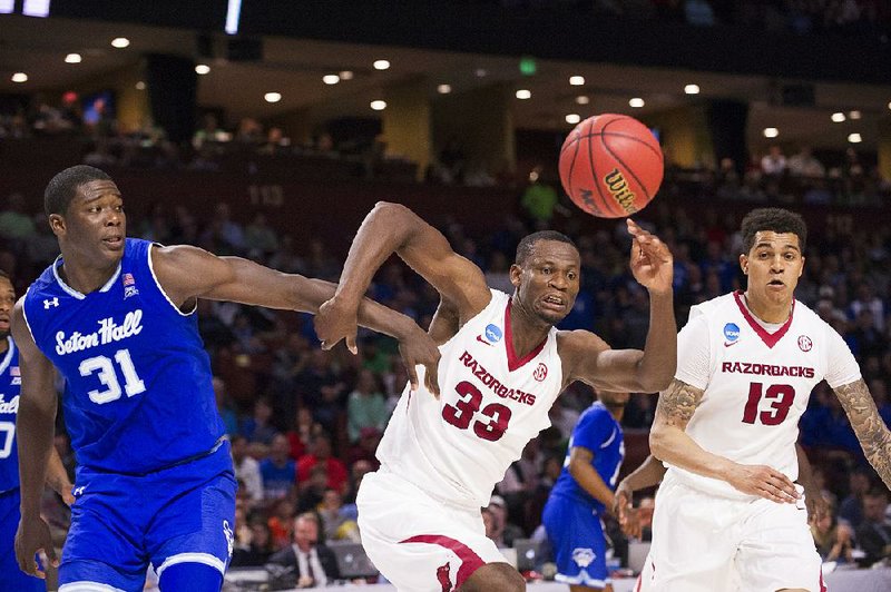 Arkansas’ Moses Kingsley (right) and Seton Hall’s Angel Delgado chase a loose ball during Friday’s game. Kingsley had 23 points, 6 rebounds and 4 blocks.