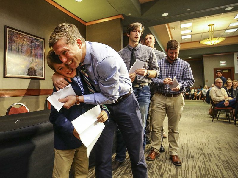Steven Rogers hugs his son Baylor after they opened dad’s match letter together during Match Day activities Friday in Little Rock. Rogers was matched with internal medicine at Emory University in Atlanta. 