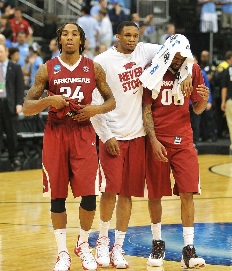 Arkansas players Michael Qualls (from left), Keaton Miles and Rashad Madden leave the court after the Razorbacks’ 87-78 loss to North Carolina in the second round of the NCAA Tournament in 2015. The Razorbacks and Tar Heels are meeting in the NCAA Tournament today for the sixth time.
