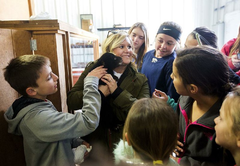 Erica Parker of Locust Grove, Okla., (center) holds a 7-week-old bear cub at the Wild Wilderness Drive Through Safari in Gentry, which was found to have violated U.S. Department of Agriculture regulations from 2012-16. 